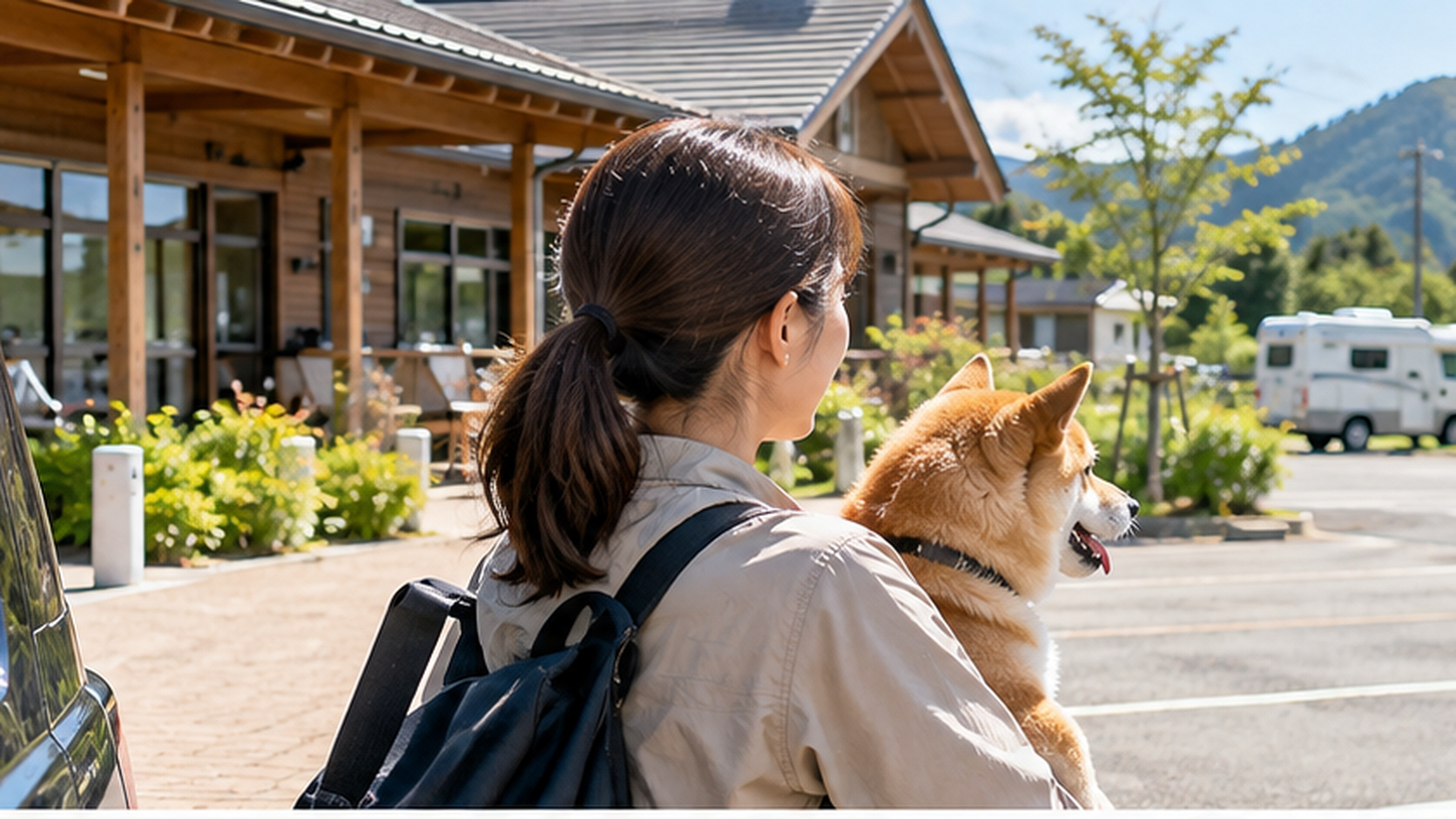 犬を連れた飼い主が車中泊施設の駐車場を見渡し、滞在場所を検討している様子