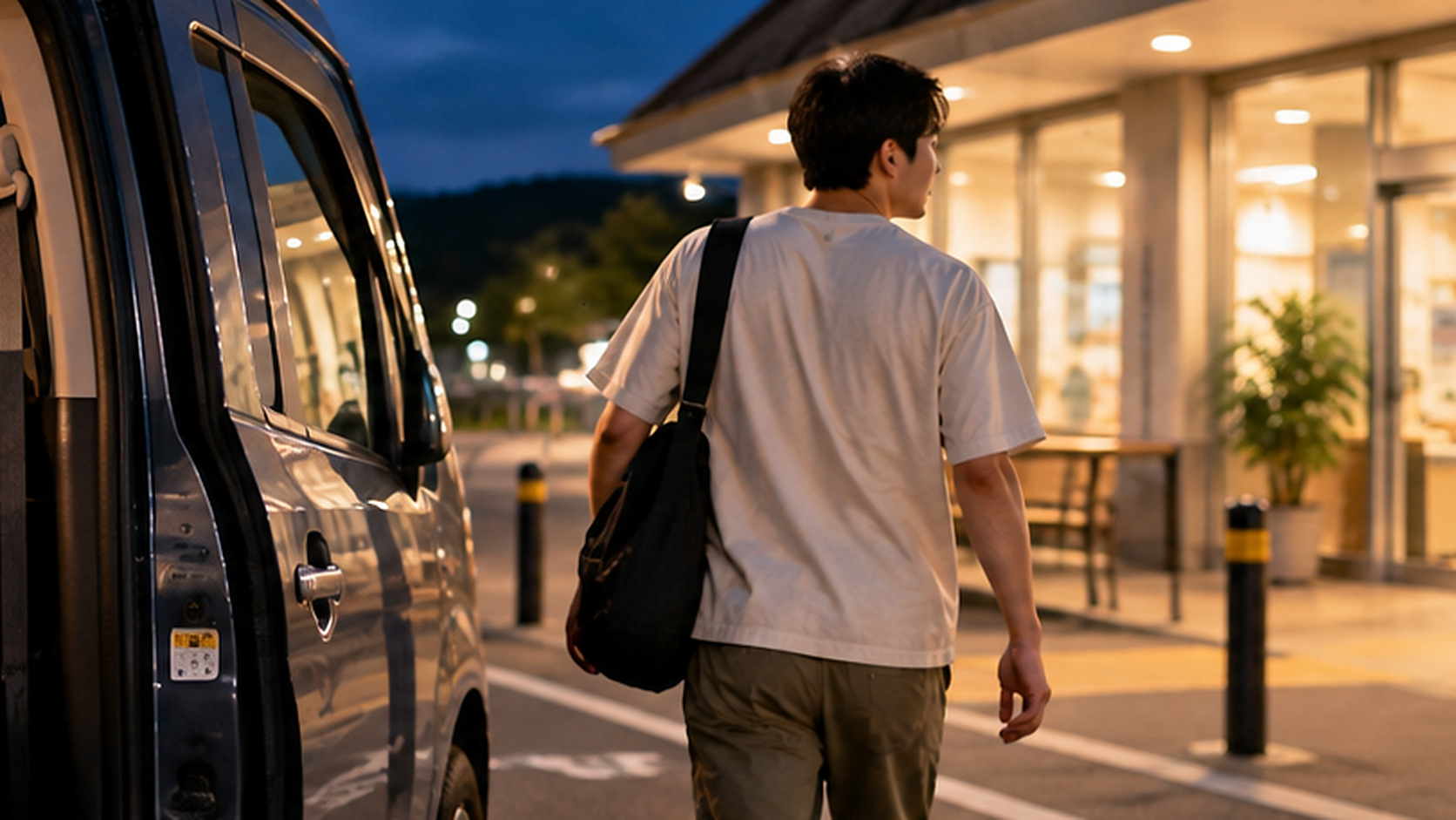 車中泊の車内に扇風機を残し、暑さを避けるために建物へ向かう男性